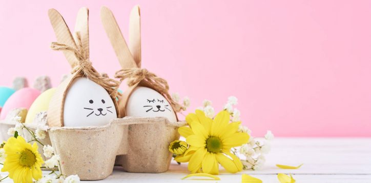 easter-colored-eggs-with-painted-faces-paper-tray-with-decorationd-pink-background-2